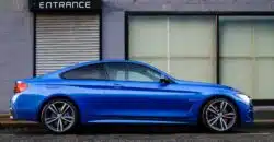 voiture bleue garé devant un bâtiment gris