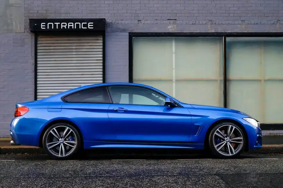 voiture bleue garé devant un bâtiment gris